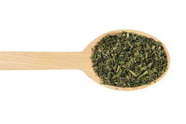 Kurutulmuş ısırgan otu ya da beyaz arka planda izole edilmiş tahta kaşıkta latin Utrikae yaprağı. Şifalı bitkiler. Bitkisel ilaçlar. alternatif tıp