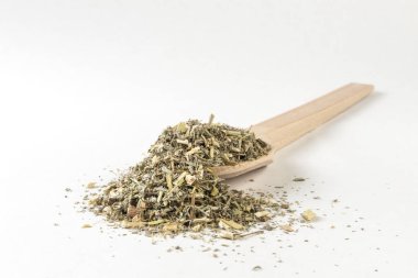Wormwood bitkisi ya da latin Absinthii Herba bitkisindeki tahta kaşıkta beyaz arka planda izole edilmiş bitki. Şifalı bitkiler. Bitkisel ilaçlar. alternatif tıp