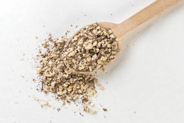 Karahindiba kökü ya da beyaz arka planda izole edilmiş tahta kaşıkla Latince Taraxaci radx. Şifalı bitkiler. Bitkisel ilaçlar. alternatif tıp