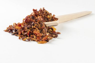 Beyaz arka planda izole edilmiş tahta kaşıkta kurutulmuş domatesler. Baharatlar ve yemek malzemeleri. Baharatlar ve yemek malzemeleri.