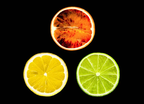 Arancione rosso siciliano, limone e lime isolati sullo sfondo nero — Foto Stock