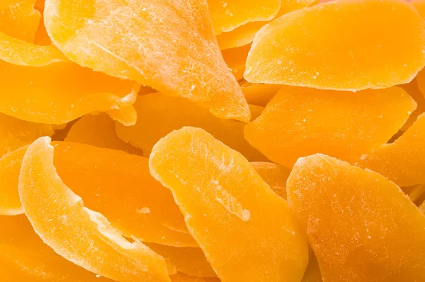 Şekerlenmiş mango dilimleri yakın çekim üstten görünüm kurumuş. Arka plan, doku.