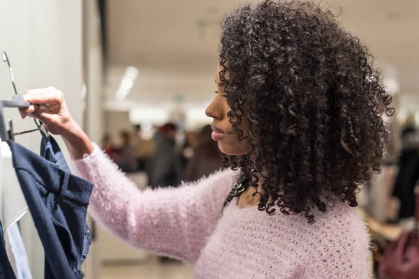 Schwarze Frau kauft Kleidung in einem Geschäft ein — Stockfoto