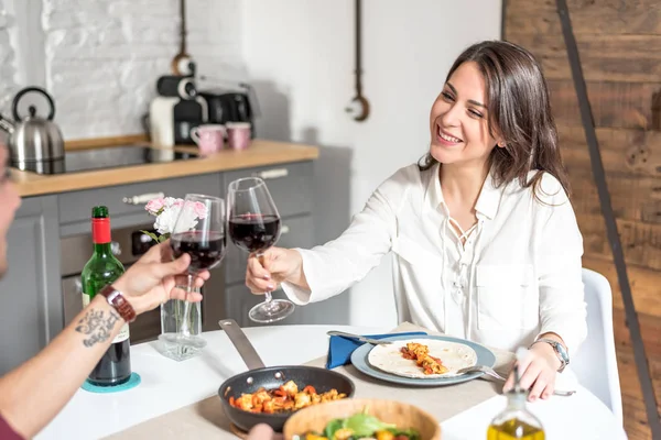 Щаслива молода пара їсть і п'є вино вдома — стокове фото