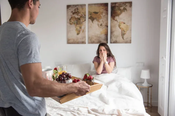 Feliz joven pareja enamorada sorprendiéndose con regalos — Foto de Stock