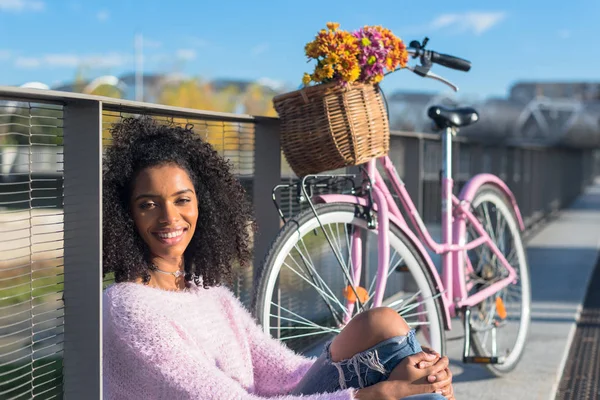 Schwarze junge Frau sitzt mit ihrem Oldtimer-Fahrrad am Fluss — Stockfoto