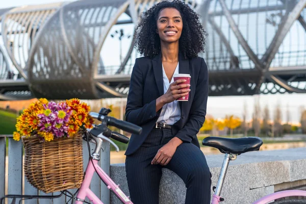 Business black woman with vintage bicycle drinking coffe