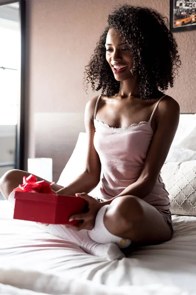 Γυναίκα στο κρεβάτι με ένα δώρο του Αγίου Βαλεντίνου ή γενέθλια — Φωτογραφία Αρχείου