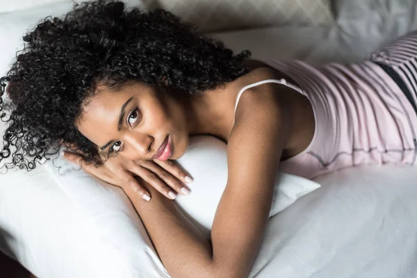 Mujer feliz en la cama sonriendo y estirándose mirando a la cámara en t —  Fotos de Stock