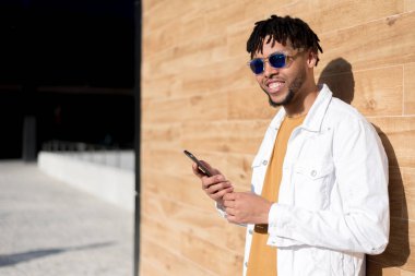 genç adam telefonunu kullanarak ve yakın kadar izole mutlu müzik açık