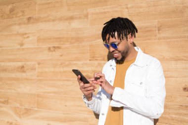 genç adam telefonunu kullanarak ve yakın kadar izole mutlu müzik açık