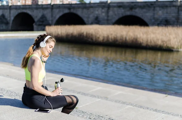 Zdrowa kobieta, odpoczynku i słuchania muzyki z telefonu komórkowego podczas wykonywania jogi i ćwiczeń — Zdjęcie stockowe
