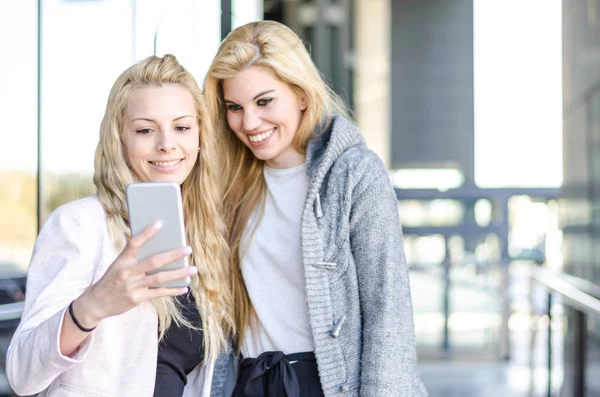Blondýna studentů přátelé smát, pomocí mobilního telefonu a tabletu — Stock fotografie