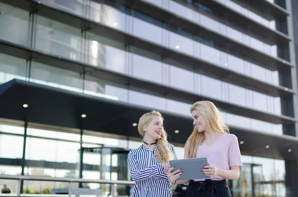 Blondýna studentů přátelé smát, pomocí mobilního telefonu a tabletu — Stock fotografie