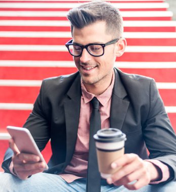 adam yakın çekim bir cep telefonu ve kahve ile