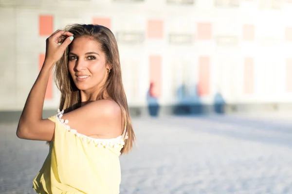 Unga vackra kvinnan ler isolerade närbild utomhus med en gul klänning — Stockfoto