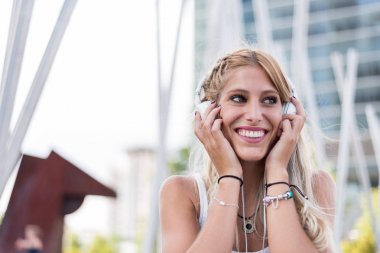 Müzik açık havada dinlerken kulaklık ile mutlu sarışın kadın 