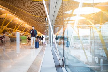 Havaalanında cep telefonuyla yürüyen adam açık