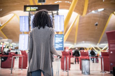 Havaalanında Uçus tarifesi Bilgi panelinde bakarak kadın 