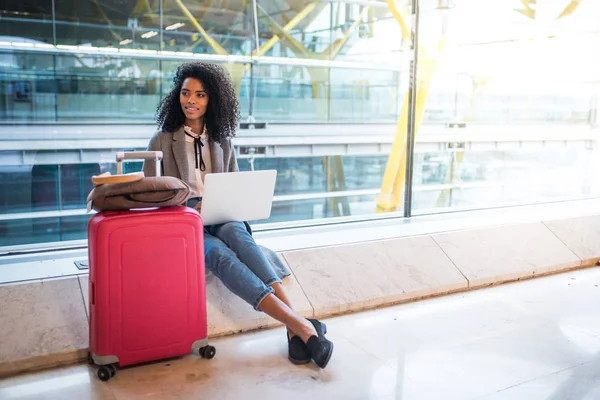 Mujer que trabaja con el ordenador portátil en el aeropuerto esperando en la ventana — Foto de Stock