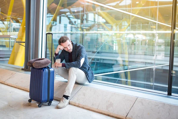 Mann verärgert, traurig und wütend am Flughafen, sein Flug hat Verspätung — Stockfoto