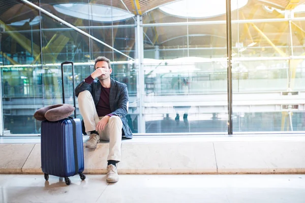 Mann verärgert, traurig und wütend am Flughafen, sein Flug hat Verspätung — Stockfoto