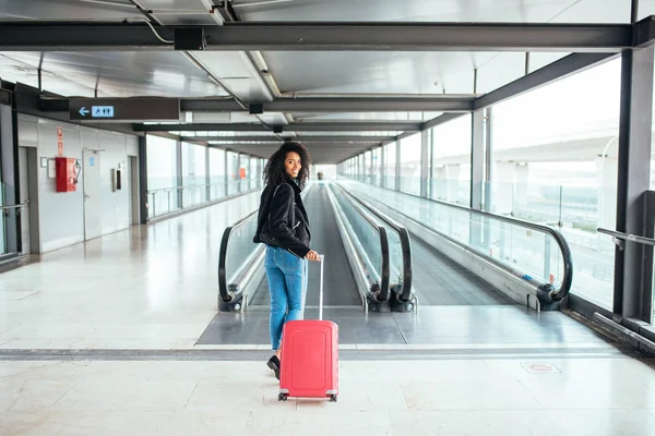 Schwarze Frau auf dem Laufsteg am Flughafen mit einem rosafarbenen Sui — Stockfoto