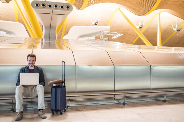 若い魅力的な男、lapto の使用空港で座っています。 — ストック写真