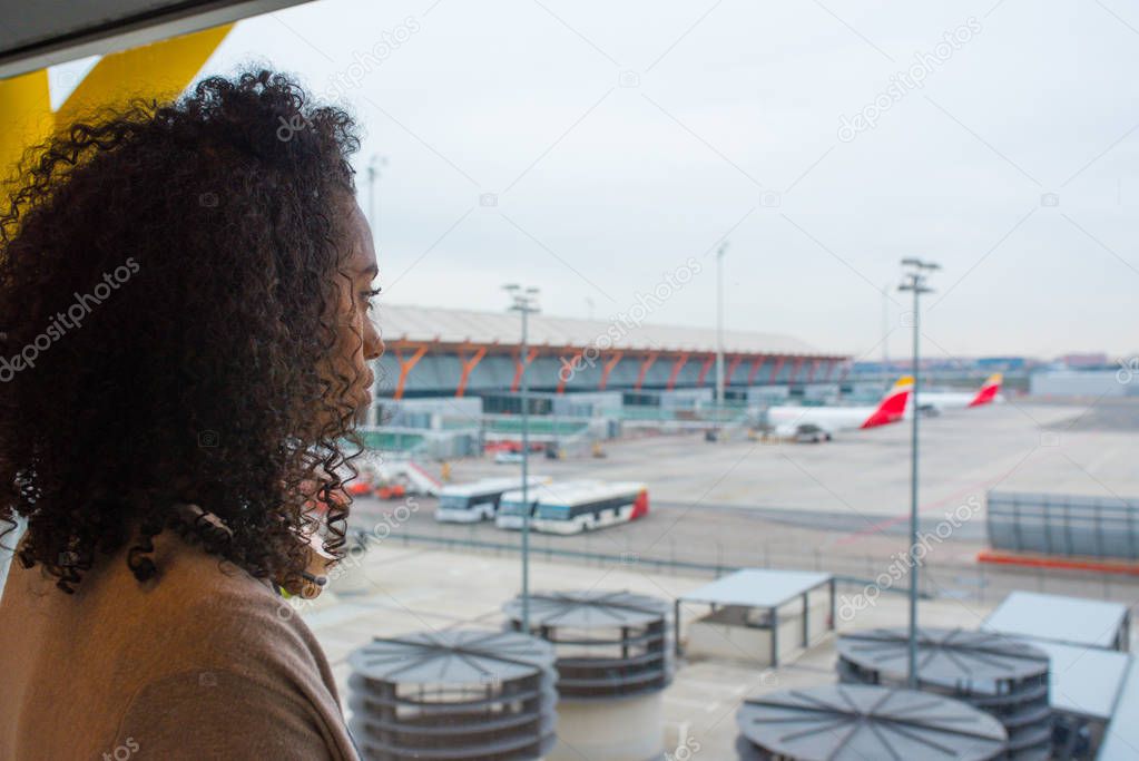 black woman looking trough airport window 