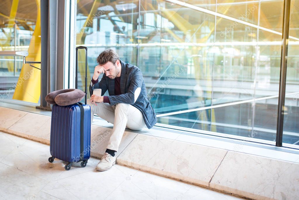 Man unhappy and frustrated at the airport his flight is cancelle