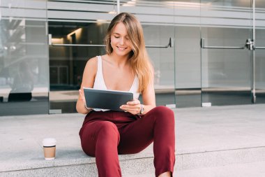 Tablet merdivenlerde oturan güzel genç kadın
