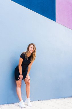 Mutlu güzel genç kadın tarafından renkli duvar poz