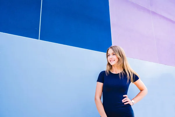 Счастливая красивая молодая женщина позирует у красочной стены — стоковое фото