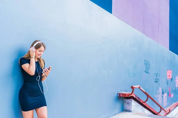 Feliz joven mujer escuchando música en el teléfono móvil por un co — Foto de Stock