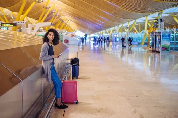 Donna in attesa del suo volo utilizzando il telefono cellulare in aeroporto — Foto Stock