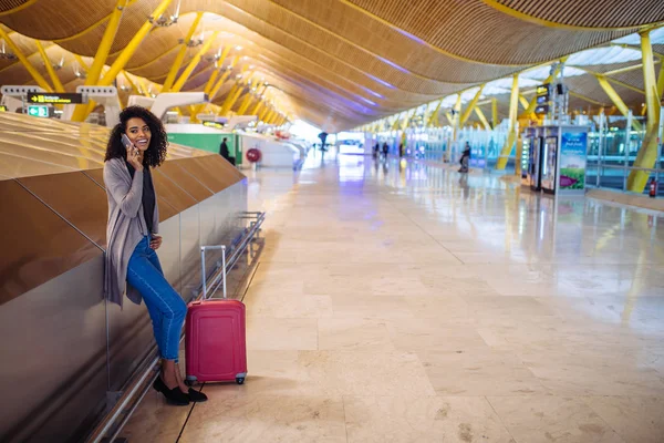 女人在等她的航班在机场使用手机 — 图库照片