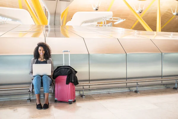 Attraktive Frau am Flughafen sitzt und mit Laptop arbeitet — Stockfoto