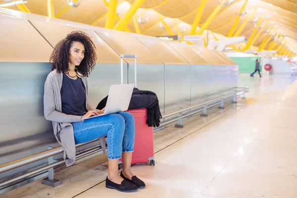 앉아서 노트북을 사용 공항에서 매력적인 여자 — 스톡 사진