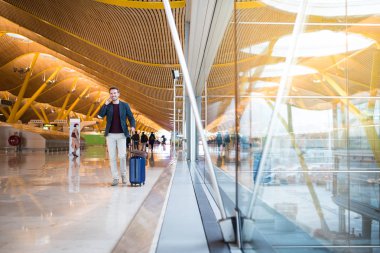 Havaalanında cep telefonuyla yürüyen adam açık