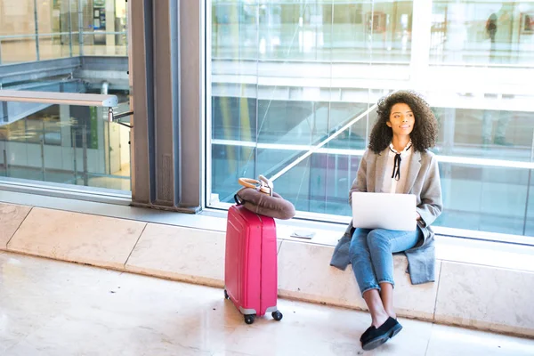 Mujer que trabaja con el ordenador portátil en el aeropuerto esperando en la ventana — Foto de Stock