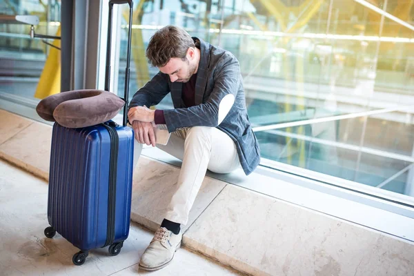 Mann verärgert, traurig und wütend am Flughafen, sein Flug hat Verspätung — Stockfoto