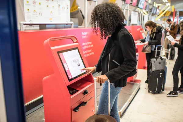 Felice donna nera utilizzando la macchina check-in in aeroporto ottenere la carta d'imbarco . — Foto Stock