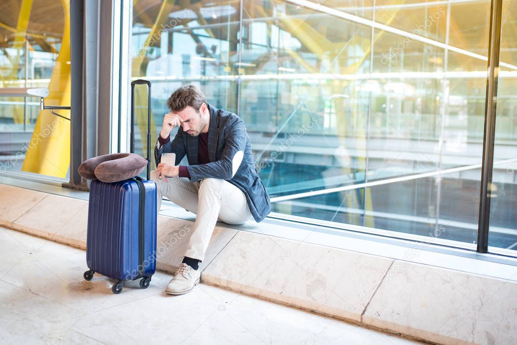 Man unhappy and frustrated at the airport his flight is canceled