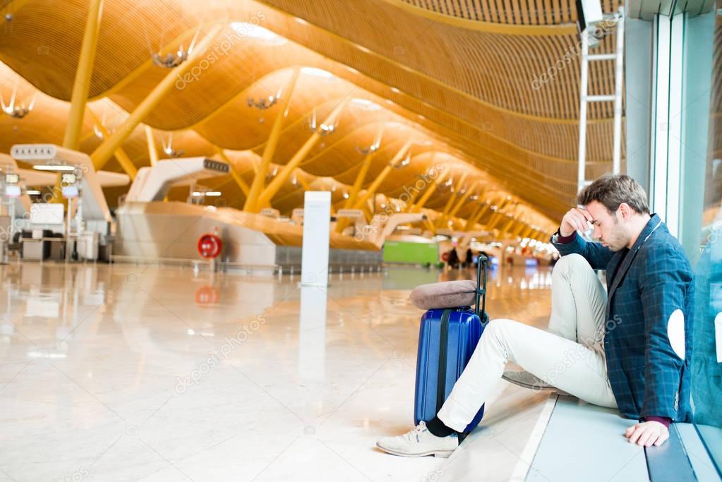 Man unhappy and frustrated at the airport his flight is canceled