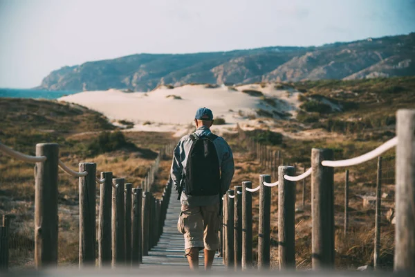 Homem caminhando em uma ponte pé de madeira na praia — Fotografia de Stock