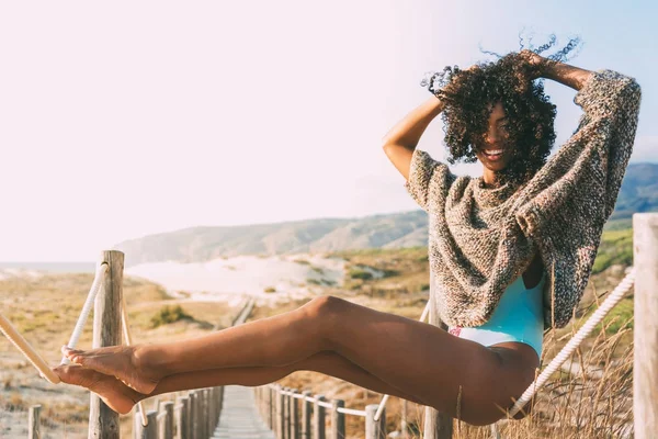 Vacker ung svart kvinna sitter i en trä gångbron på — Stockfoto