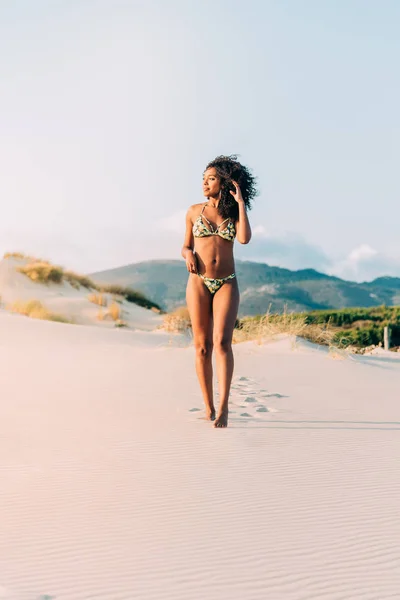Bella giovane donna in posa sulla sabbia in spiaggia — Foto Stock