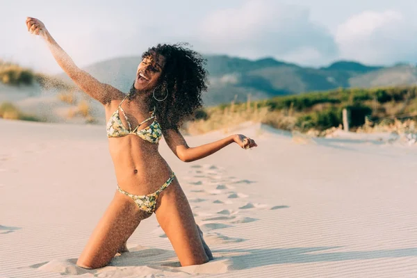 Bella giovane donna in posa sulla sabbia in spiaggia — Foto Stock