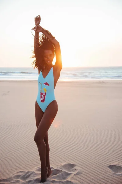 Bella giovane donna in posa sulla sabbia in spiaggia — Foto Stock