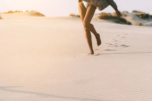 Piernas de una joven mujer negra caminando en la arena en una duna del desierto — Foto de Stock